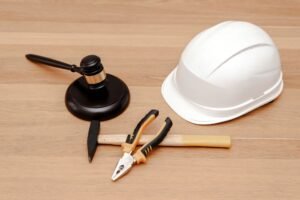 Judge gavel, safety helmet and work tools representing construction law concepts